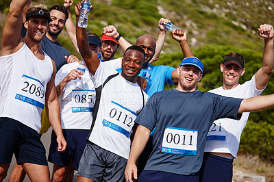 Buy stock photo A group of young men standing together with their water bottles after running a marathon