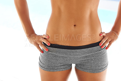 Buy stock photo Cropped shot of a woman with a toned stomach posing outdoors in sportswear