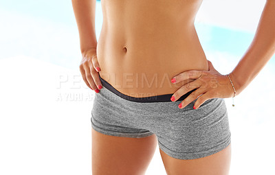 Buy stock photo Cropped shot of a woman with a toned stomach posing outdoors in sportswear