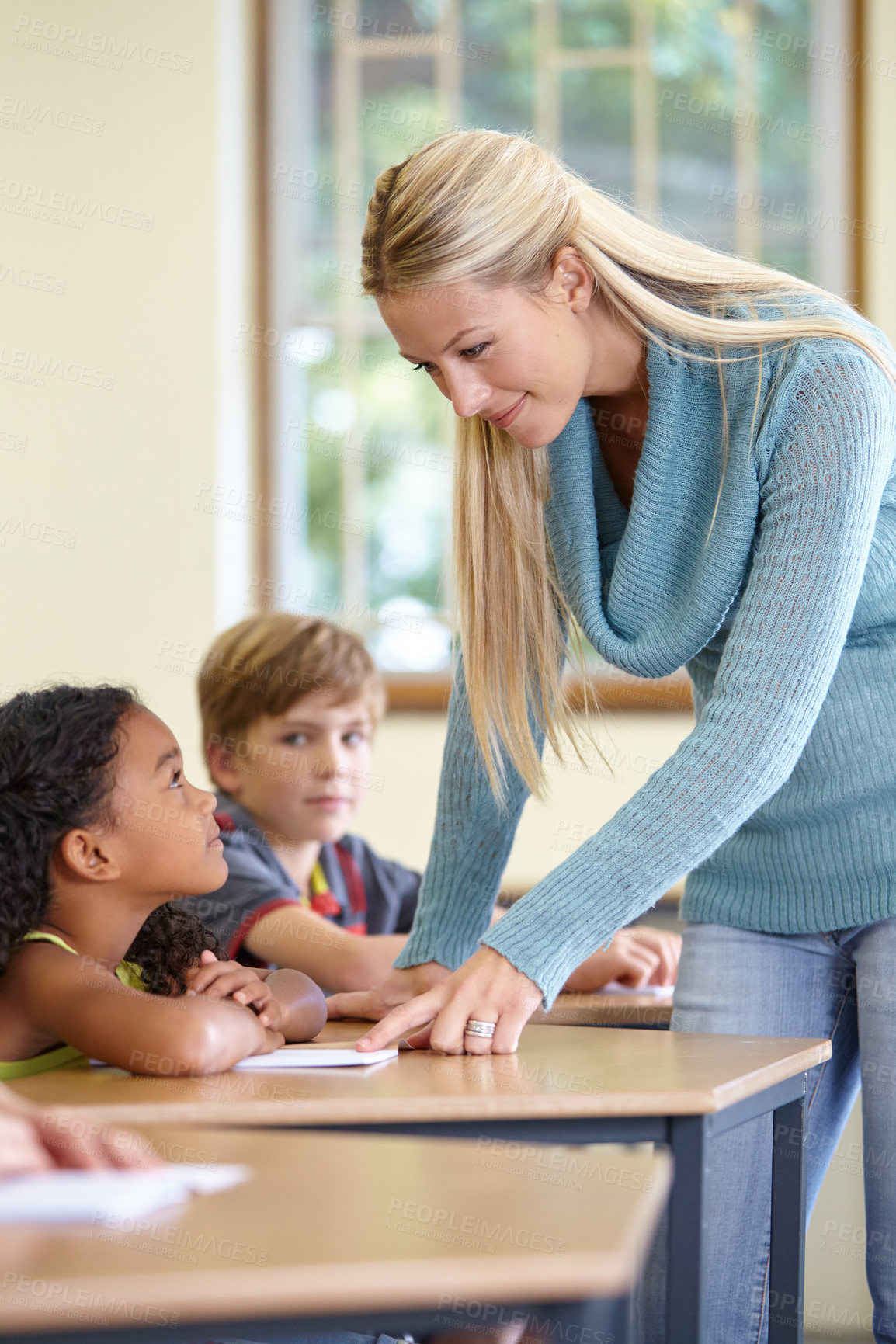 Buy stock photo Teacher, students and child in classroom for education, learning and writing or language development with support. Happy woman and girl for teaching, helping with knowledge and questions at school