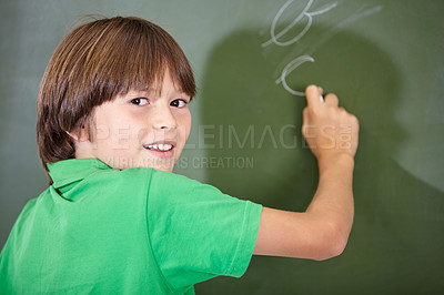 Buy stock photo Portrait, happy and boy writing on a chalkboard for child development, confidence and art for learning. Academic, creative and kid student drawing in the classroom with face, school and answers