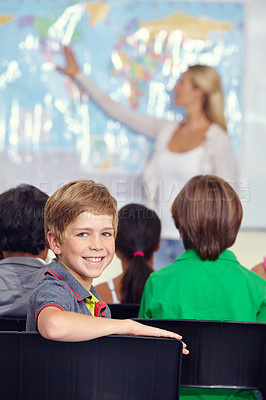 Buy stock photo Kid, portrait and classroom with teacher for education, teaching and geography lesson or support in primary school. Face of a boy, child or students for learning, map information and world knowledge