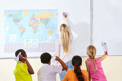 Buy stock photo Teacher, woman and children in a classroom, playing and knowledge with information, paper planes and learning. School, group and educator writing on a board, studying and geography with students