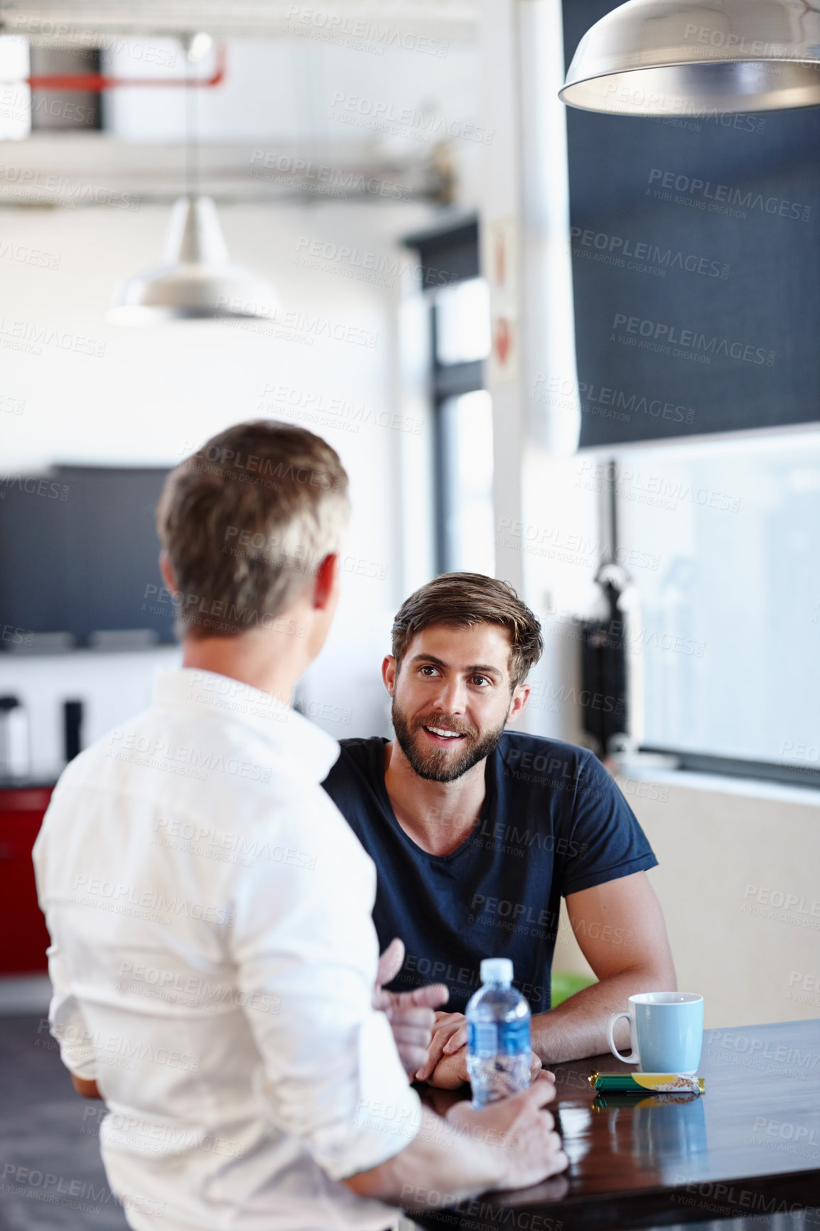 Buy stock photo Shot of two handsome businessmen having a discussion in the office