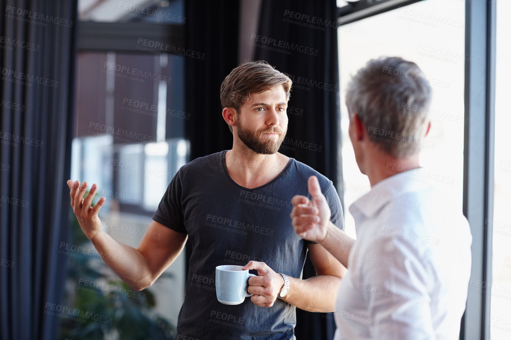 Buy stock photo Shot of two handsome businessmen having a discussion in the office