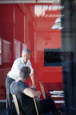 Buy stock photo Shot of two handsome businessmen having a discussion in the office