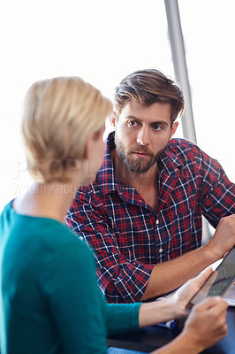 Buy stock photo Shot of two colleagues having a discussion in the office