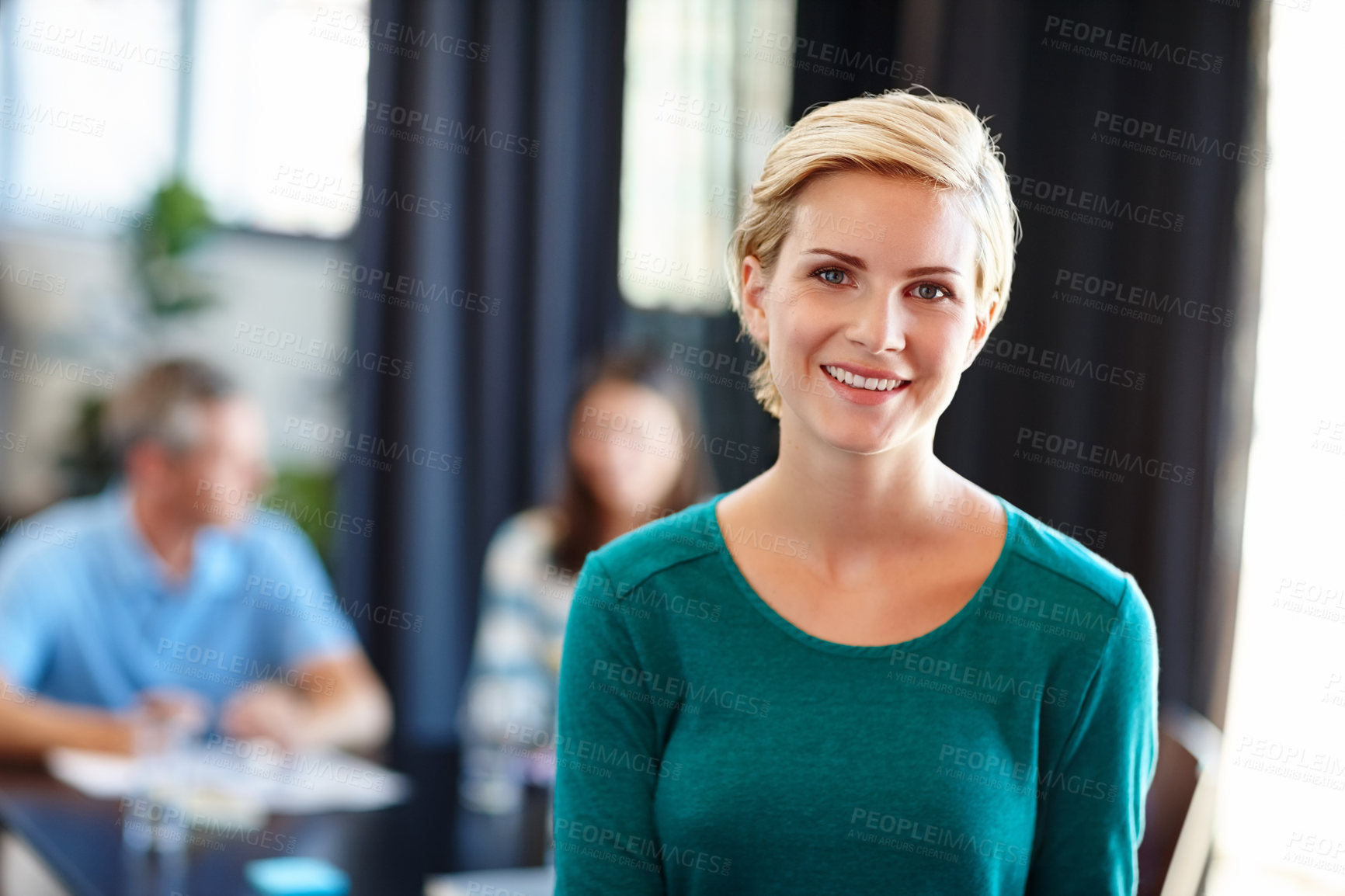 Buy stock photo Portrait of a beautiful woman with her colleagues blurred in the background