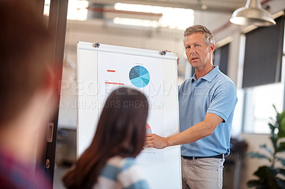 Buy stock photo Shot of a mature man doing a presentation for his colleagues