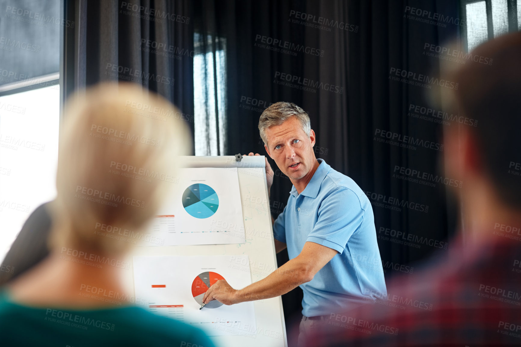 Buy stock photo Shot of a mature man doing a presentation for his colleagues