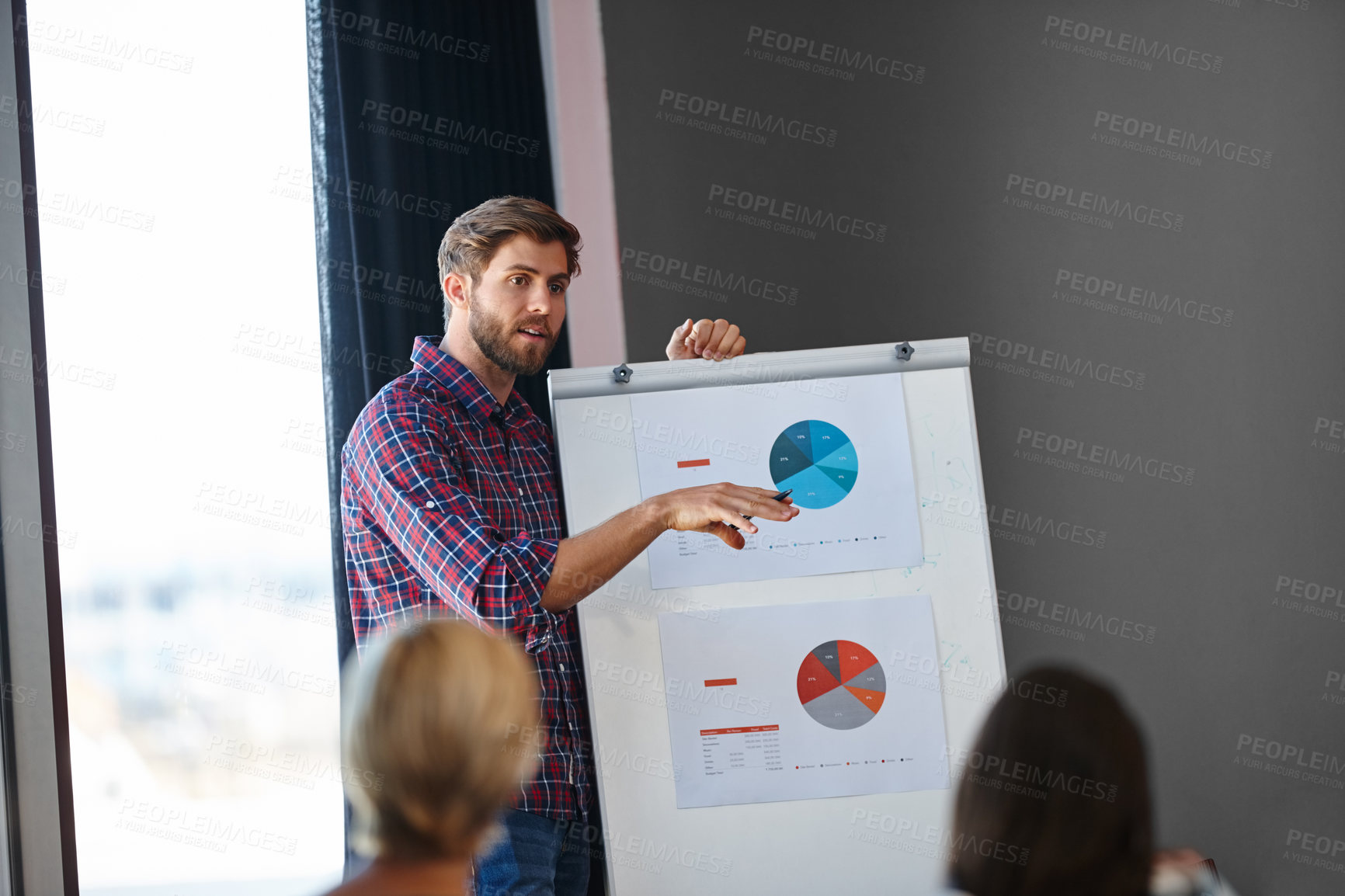 Buy stock photo Shot of a handsome young man doing a presentation for his colleagues