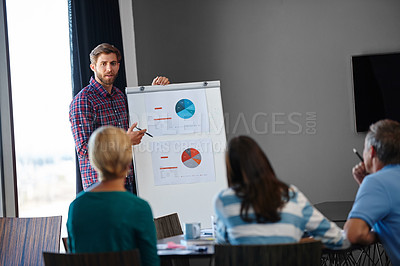 Buy stock photo Shot of a handsome young man doing a presentation for his colleagues