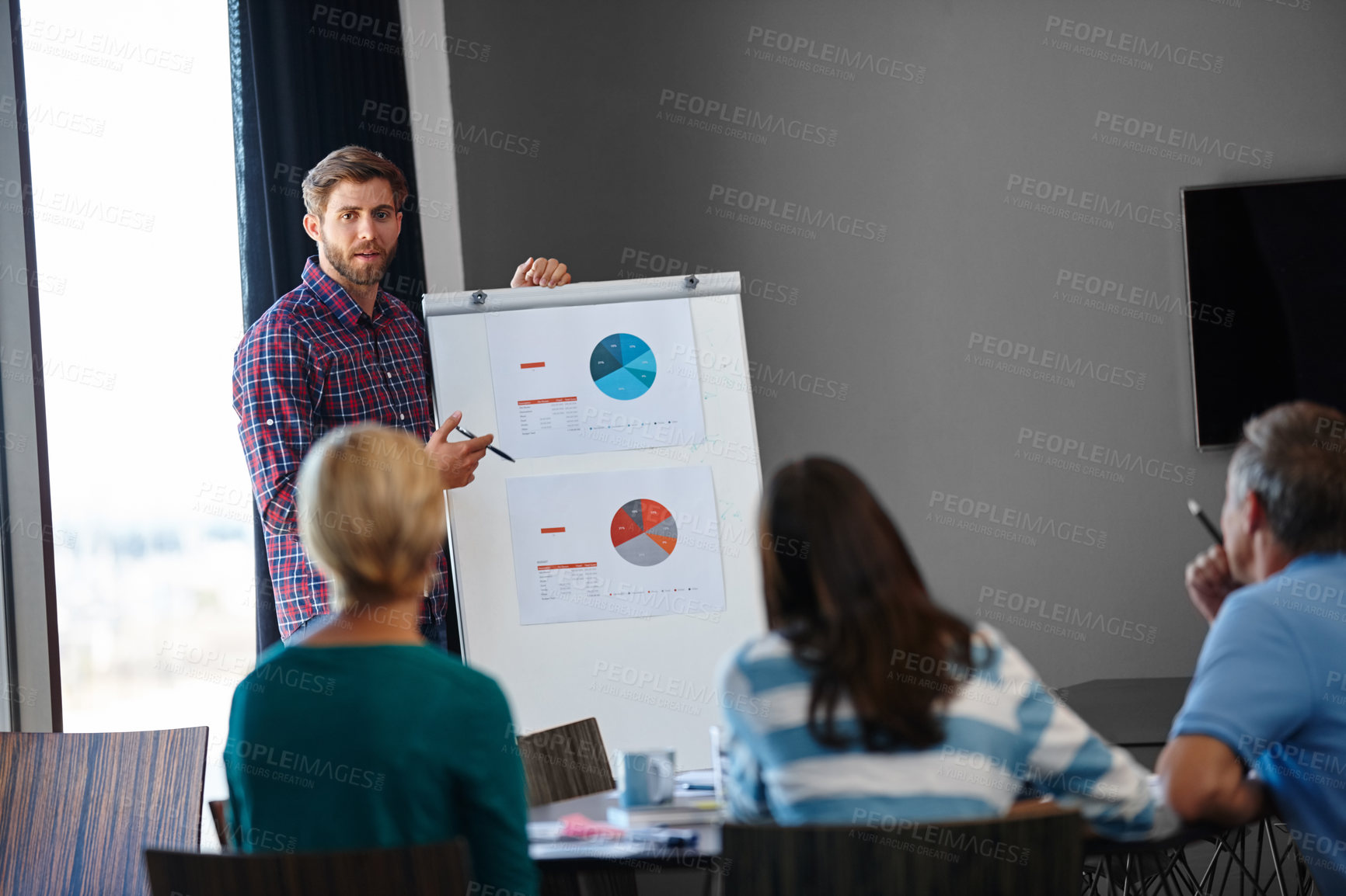 Buy stock photo Shot of a handsome young man doing a presentation for his colleagues