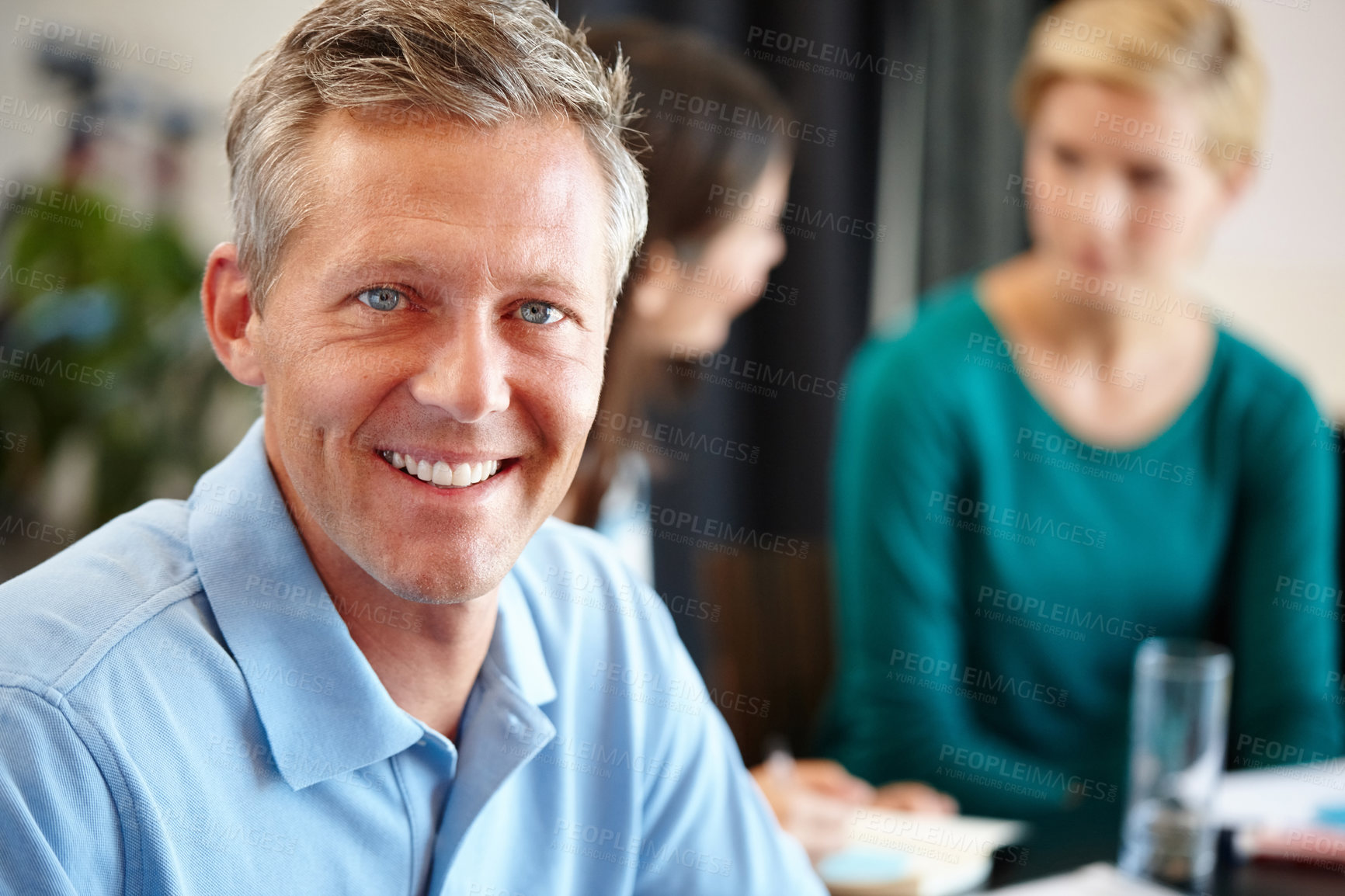 Buy stock photo Portrait of a mature man in a conference room with his colleagues in the background