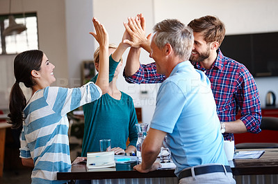 Buy stock photo Shot of a group of coworkers high-fiving in an office