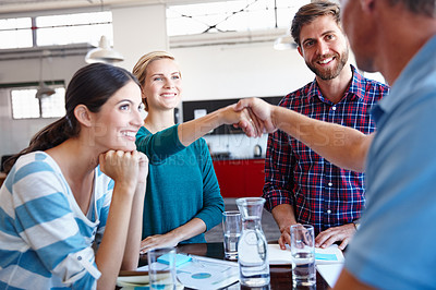 Buy stock photo Shot of coworkers shaking hands in an office
