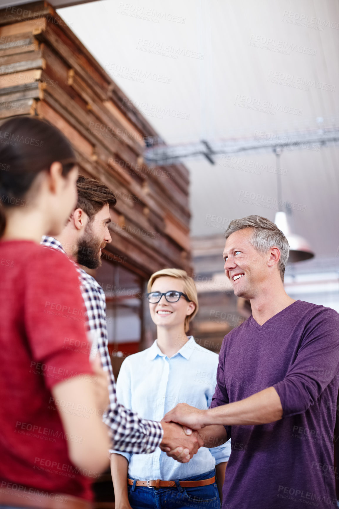 Buy stock photo Cropped shot of two coworkers shaking hands