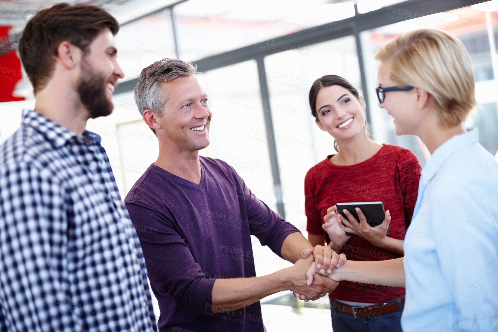 Buy stock photo Cropped shot of two coworkers shaking hands