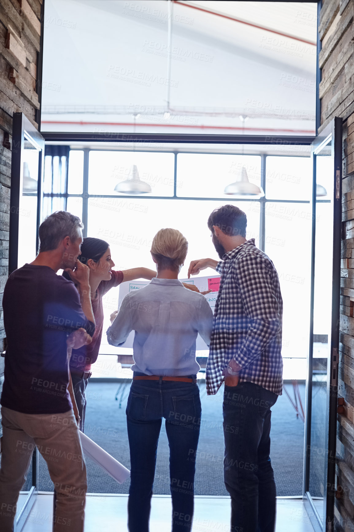 Buy stock photo A group of colleagues looking over some plans