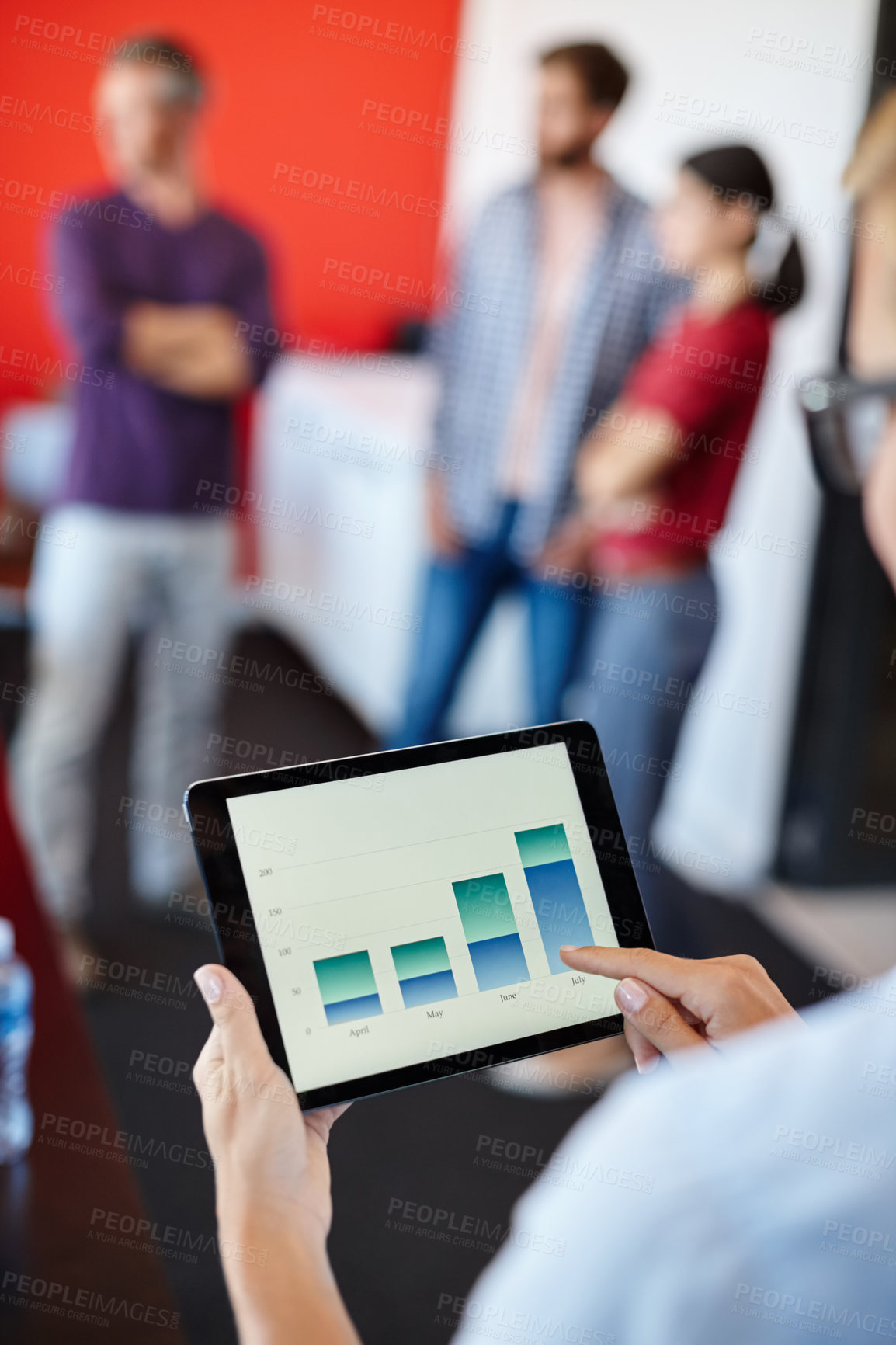 Buy stock photo Over the shoulder shot of a female designer looking at graphs on a digital tablet