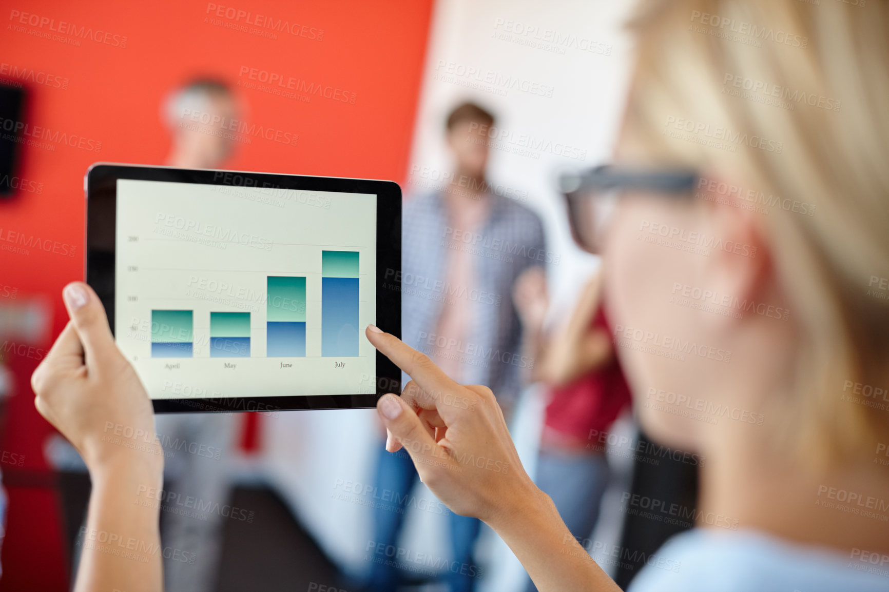 Buy stock photo Over the shoulder shot of a female designer looking at graphs on a digital tablet