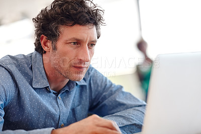 Buy stock photo Cropped shot of a handsome businessman working on a laptop