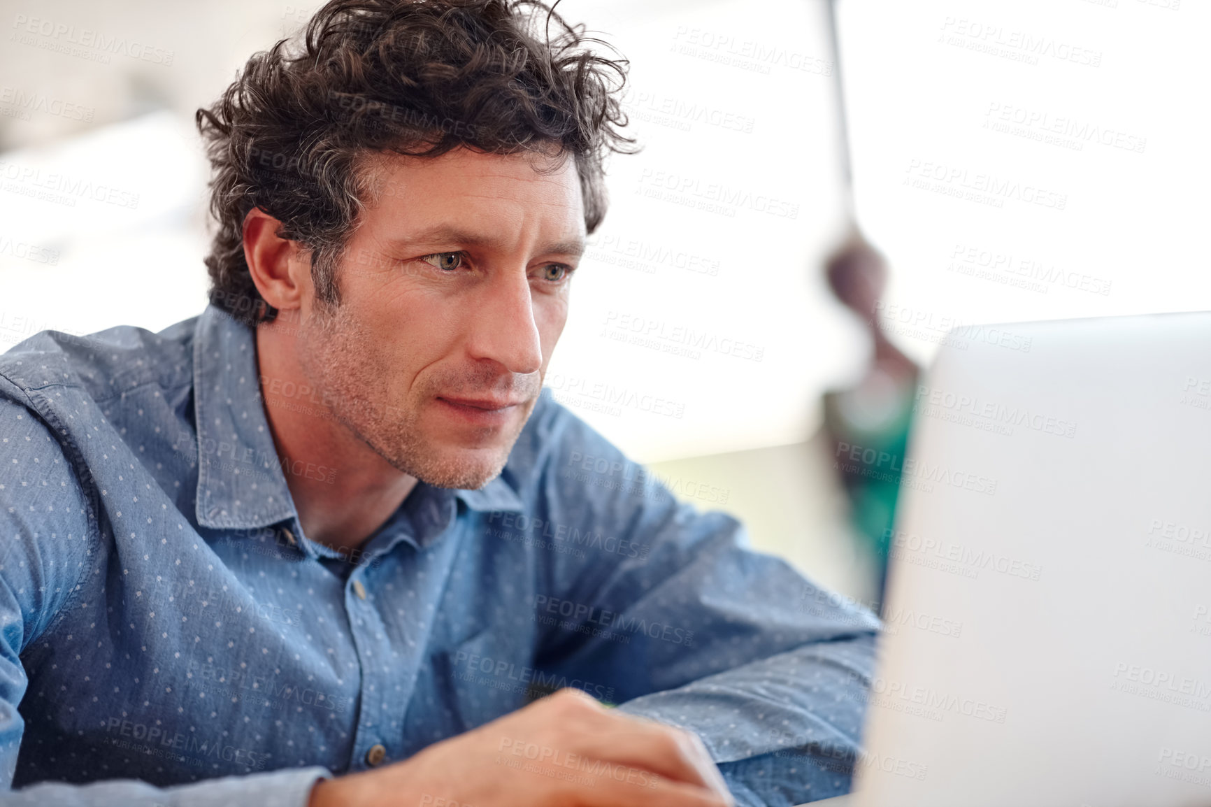 Buy stock photo Cropped shot of a handsome businessman working on a laptop