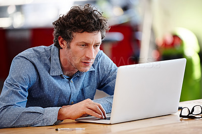 Buy stock photo Cropped shot of a handsome businessman working on a laptop