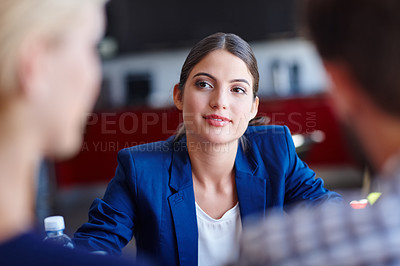 Buy stock photo Cropped shot of a young creative professional in a meeting with her coworkers