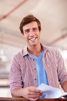 Buy stock photo Cropped portrait of a handsome young businessman looking over some paperwork