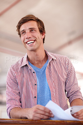 Buy stock photo Cropped shot of a handsome young businessman looking over some paperwork