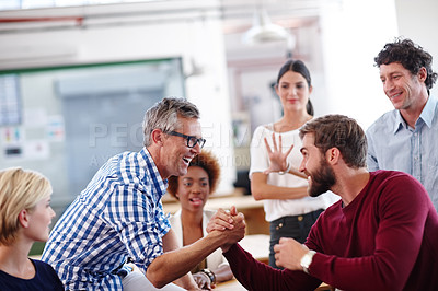 Buy stock photo Cropped shot of a group of designers looking excited during an informal office meeting
