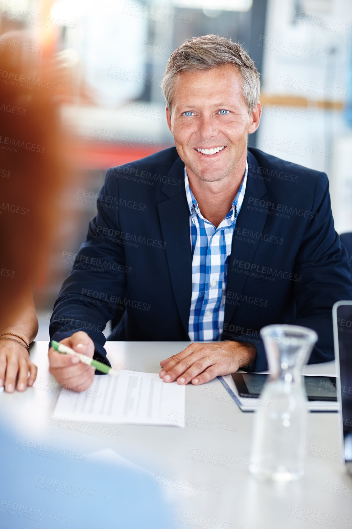 Buy stock photo A mature male manager sitting in a meeting with his team