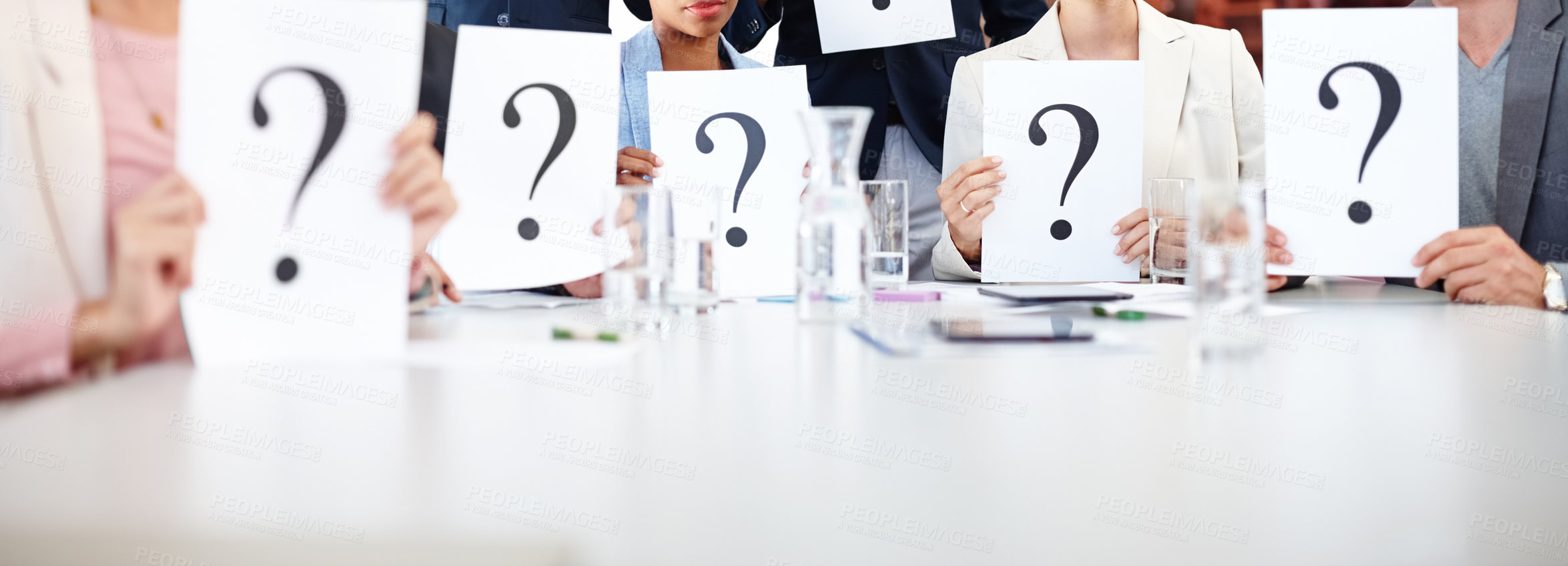 Buy stock photo Cropped shot of a group of businesspeople holding up cards with question marks on them