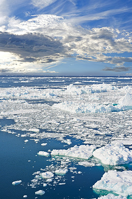 Buy stock photo Climate change, iceberg and ocean water with snow in nature, clouds or sky outdoor in Greenland. Arctic, sea or melting ice caps in environment for ecology, problem or global warming crisis in winter