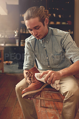 Buy stock photo Cropped shot of a handsome young man cleaning his shoes in the kitchen