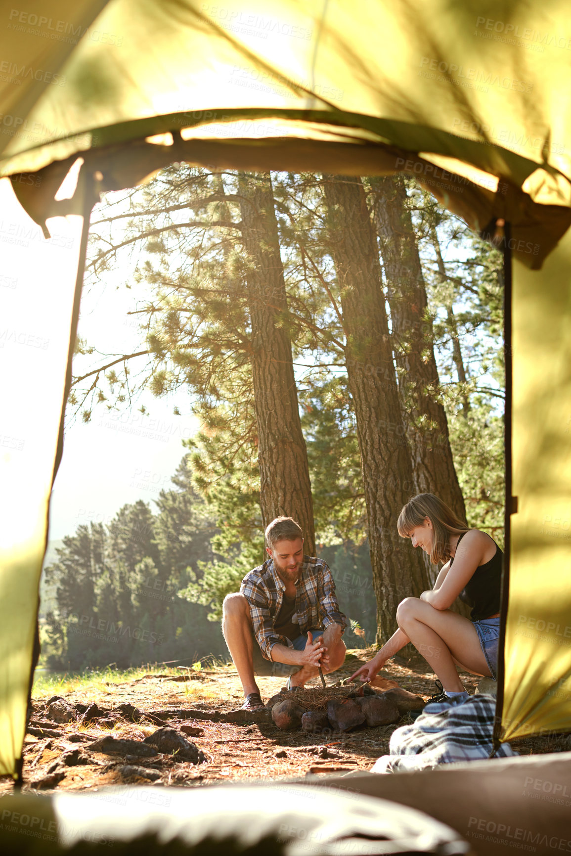 Buy stock photo Shot of a young couple on a camping trip together
