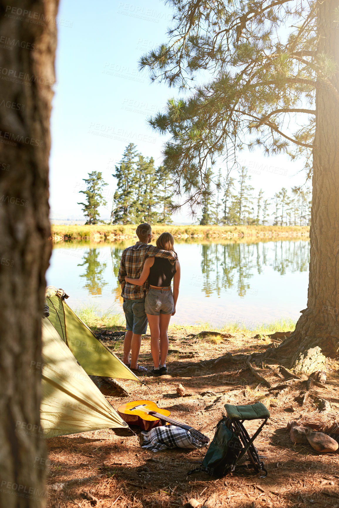 Buy stock photo Shot of a young couple camping by a lake