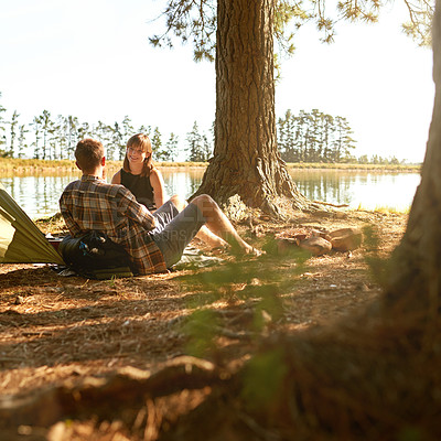 Buy stock photo Shot of a young couple camping by a lake