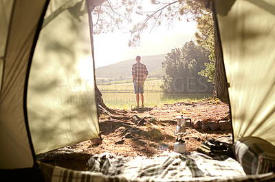 Buy stock photo Shot of a man looking out over a lake while camping