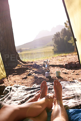 Buy stock photo Legs, couple and rest in tent for camping, summer vacation and romantic getaway with adventure. People, love and relaxing for bonding together, outdoor holiday and weekend location of nature tourism