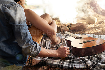Buy stock photo Cropped shot of a couple lying on a blanket next to a guitar