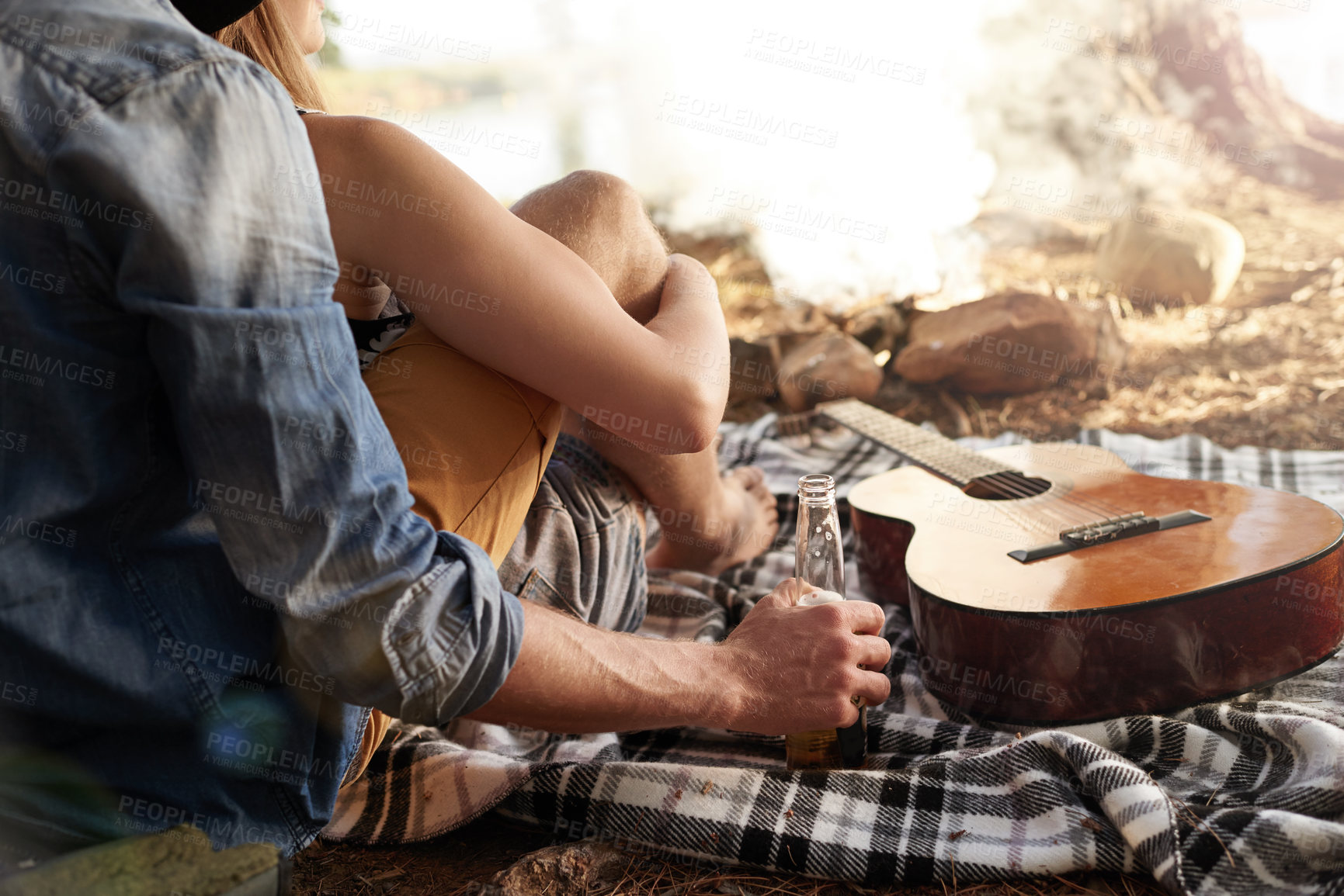 Buy stock photo Cropped shot of a couple lying on a blanket next to a guitar