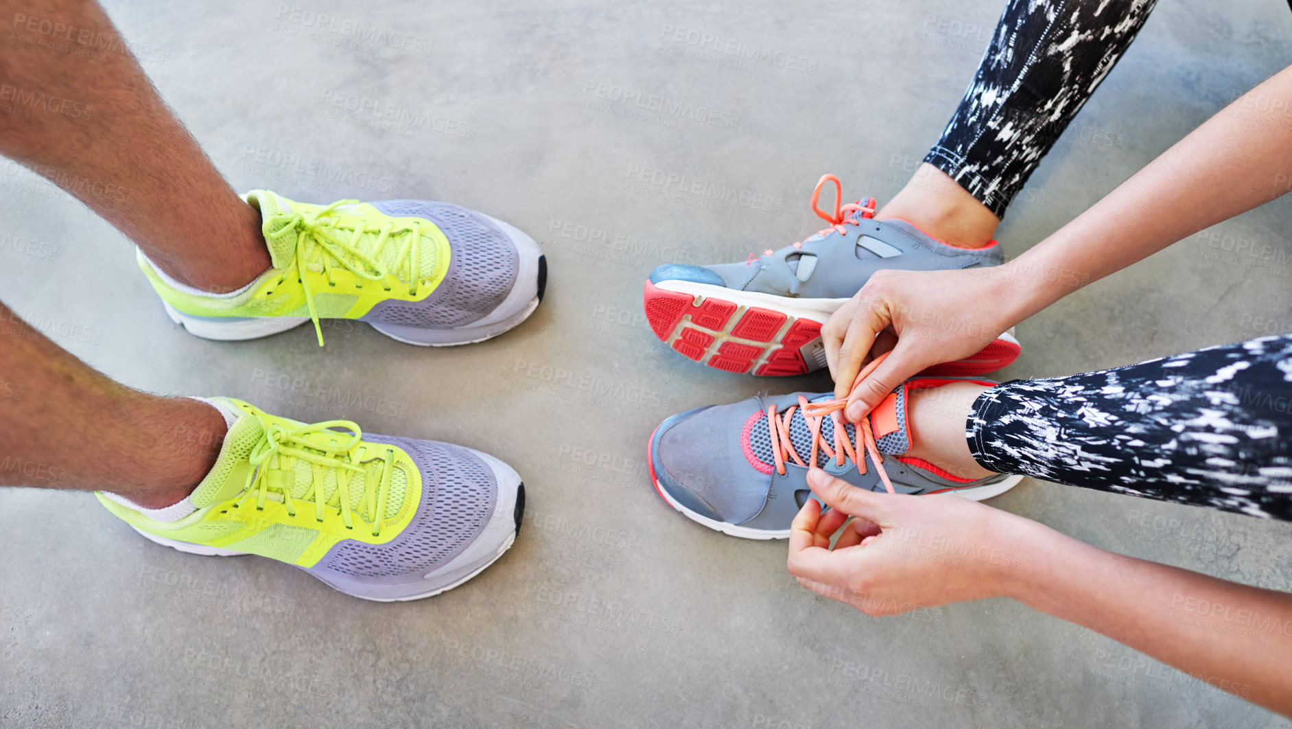 Buy stock photo High angle shot of two people tying their shoelaces before a workout
