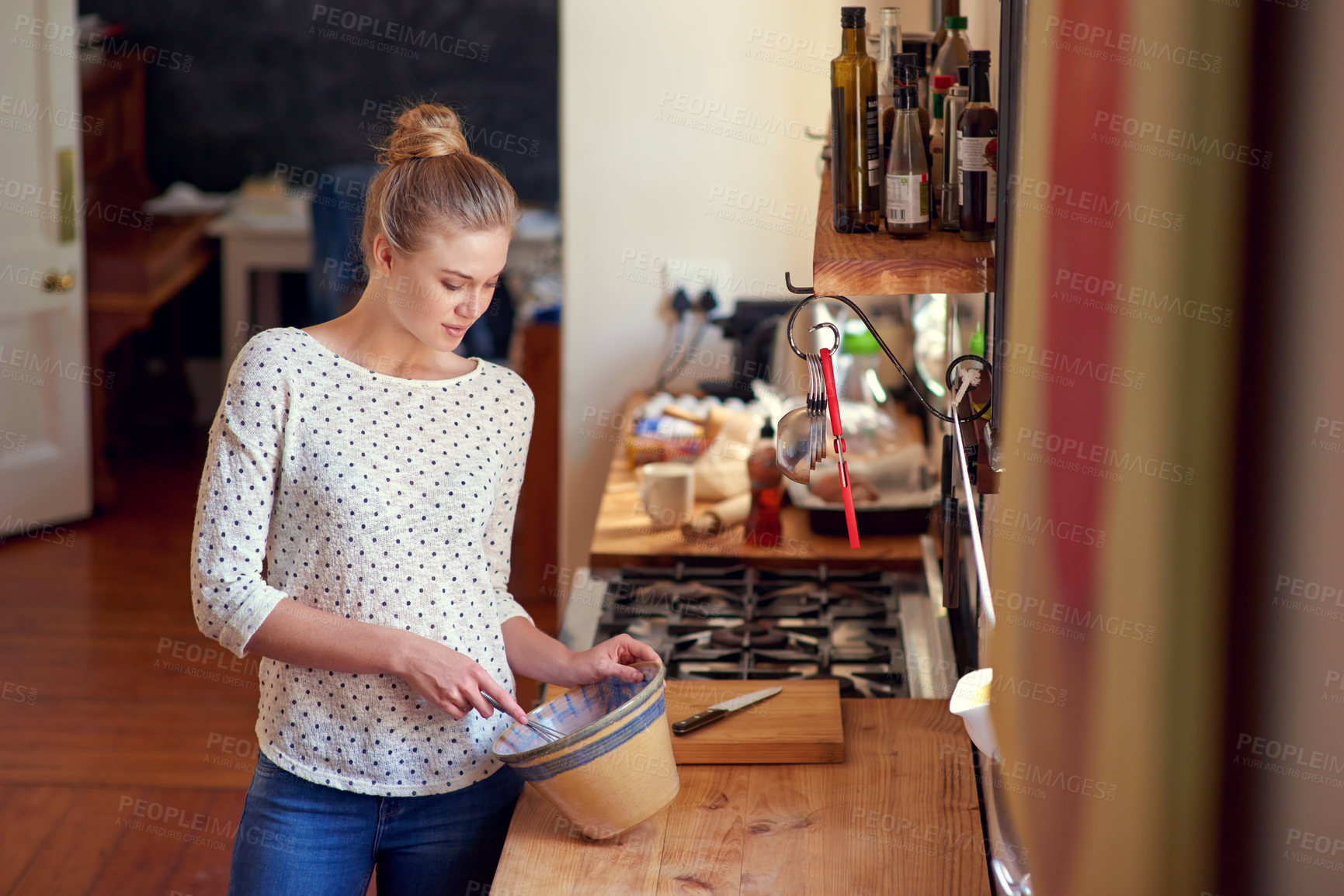 Buy stock photo Shot of a beautiful young woman preparing food in her kitchen