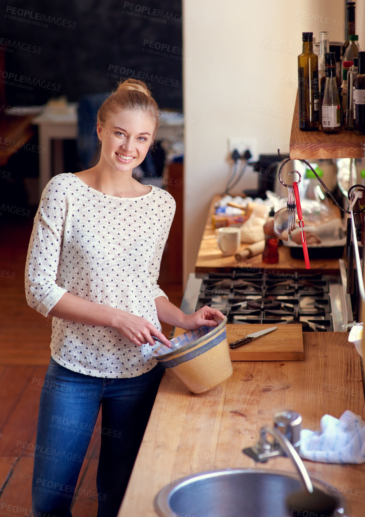 Buy stock photo Shot of a beautiful young woman preparing food in her kitchen