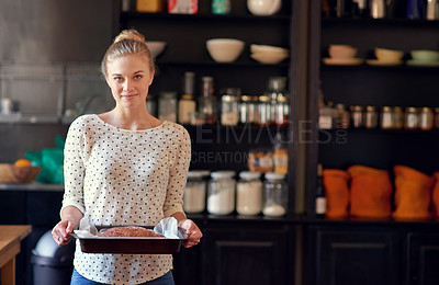 Buy stock photo Portrait of a young woman holding a freshly baked bread loaf in a pan