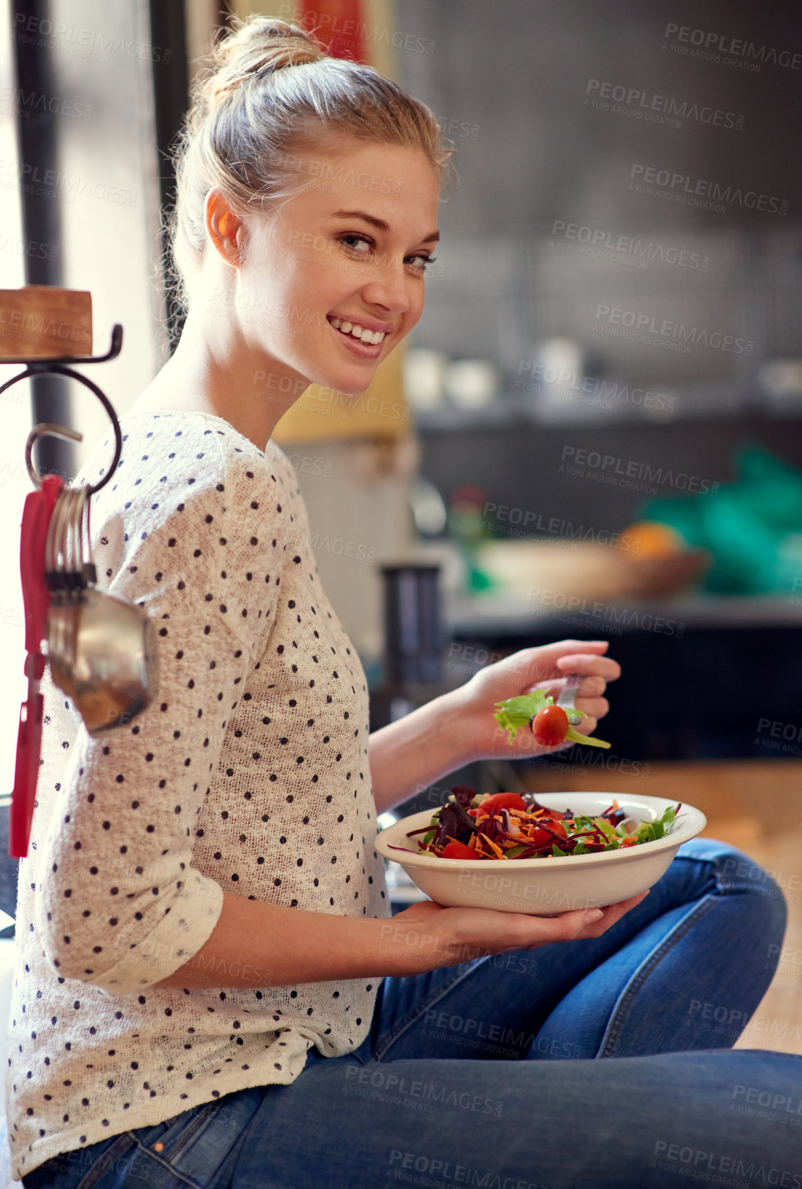 Buy stock photo Portrait of a young woman eating a healthy salad in her kitchen