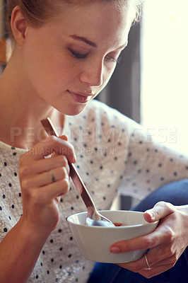 Buy stock photo Shot of a young woman eating a healthy snack at home