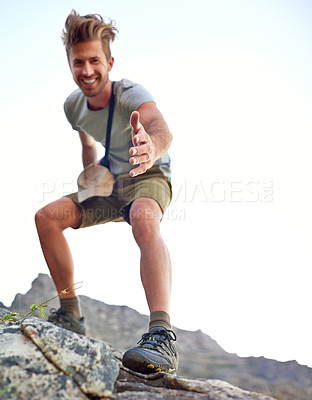 Buy stock photo Shot of a handsome young man offering you a hand up the mountain